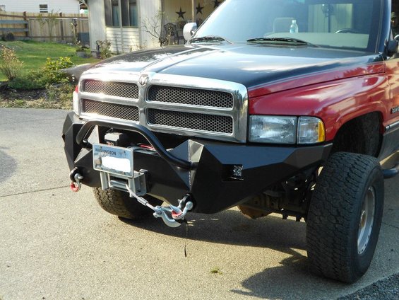 Front view of a red and black truck with a custom black bumper and winch. Washington license plate visible