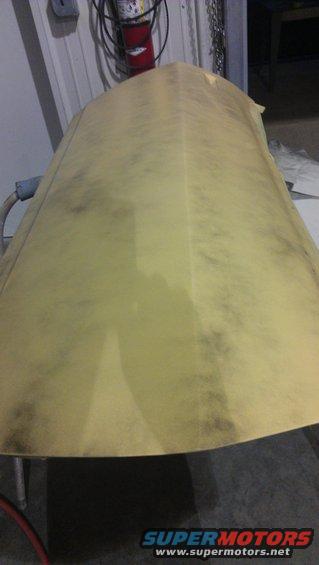 Yellow car hood with dark smudges, angled view
