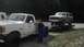 1989 Ford Bronco - A white Ford pickup truck tows a white Ford Bronco on a trailer.
