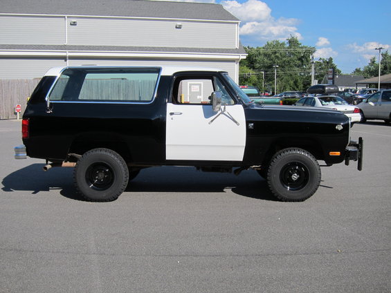Black and white SUV with chrome trim, side view, parked on asphalt