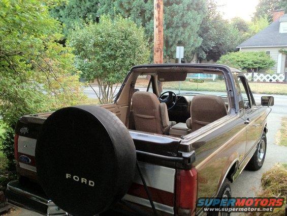 Brown Ford Bronco with spare tire on back, tan interior, viewed from rear right