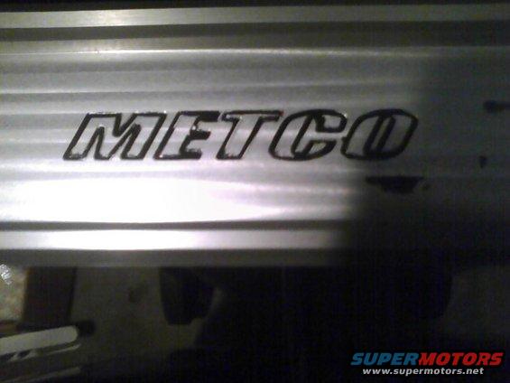METCO logo on a silver, horizontally ribbed surface