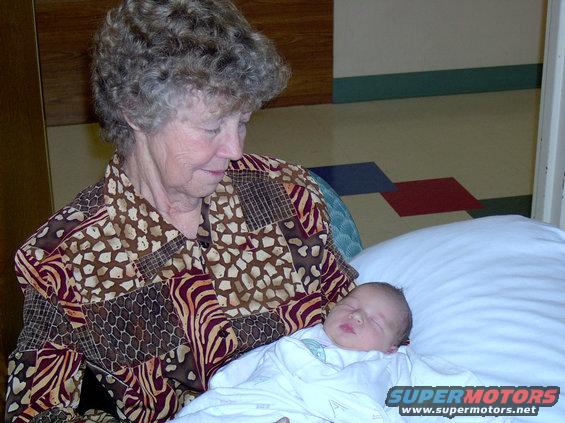 Grandmother looking down at a newborn baby wrapped in a blanket