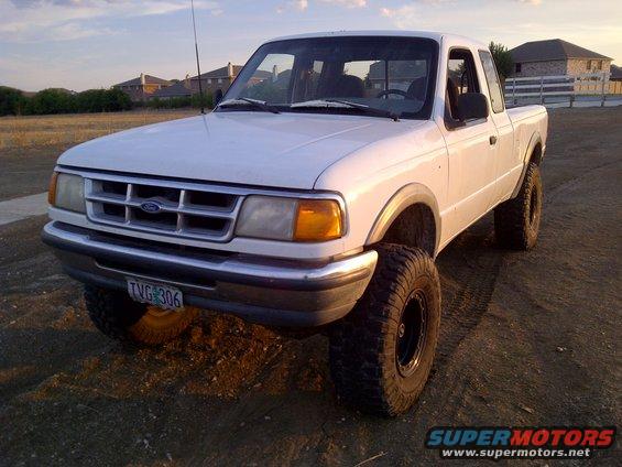 1994 Ford Ranger pickup truck, lifted, with aftermarket wheels, parked on dirt