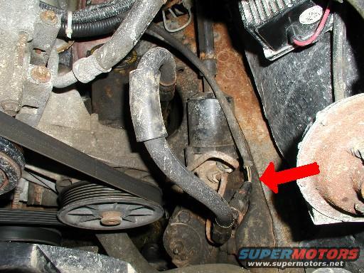 Engine components with red arrow pointing to yellow clip