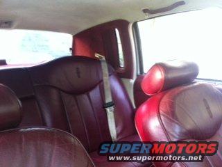 Red leather car interior with seat belts and headrests