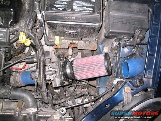 Blue car engine bay with K&N air filter, blue intake hose, and battery