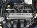 2000 Dodge Neon - The engine bay of a vehicle shows the 2.0L 16 valve engine cover and associated components.
