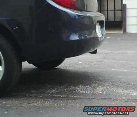 Dark blue sedan rear bumper and taillight, license plate visible