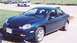 2000 Dodge Neon - A blue 2000 Dodge Neon sedan is parked on a paved surface with grass and other vehicles nearby.