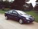 2000 Dodge Neon - A dark blue 2000 Dodge Neon sedan is parked on a dirt road with trees in the background.