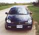 2000 Dodge Neon - A dark blue 2000 Dodge Neon is parked on a dirt road with a cornfield in the background.