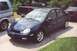 2000 Dodge Neon - A dark blue Dodge Neon sedan is parked on asphalt, with other vehicles visible in the background.
