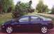 2000 Dodge Neon - Side view of a dark blue 2000 Dodge Neon sedan parked on a dirt road.