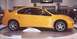 2000 Dodge Neon - A yellow sedan with a prominent rear spoiler is displayed on a turntable.