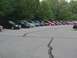 2000 Dodge Neon - A variety of sedans are parked in a lot, with trees forming a backdrop.