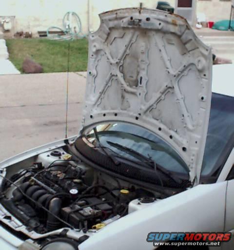 White car engine bay with hood open. Supermotors.net logo visible