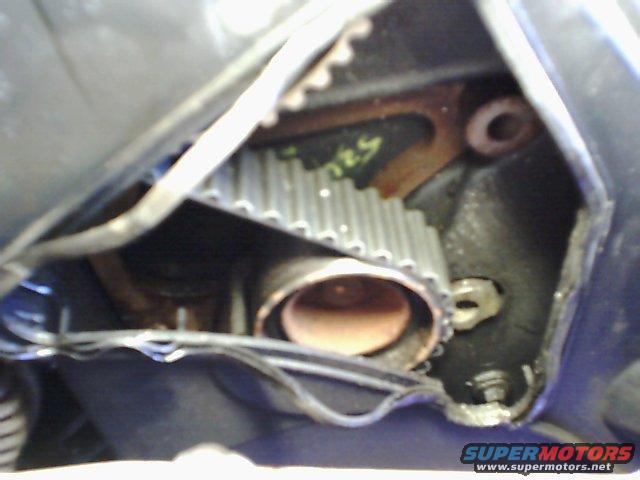 Timing belt and pulley with yellow writing on engine block