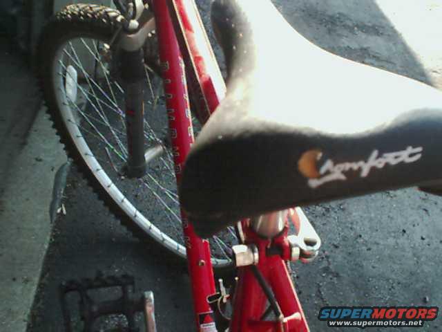 close-up of a red bicycle seat and front wheel