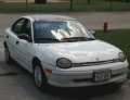 White Dodge Neon sedan, front passenger side view. License plate is visible