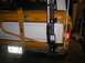 1978 Ford Bronco - A Hi-Lift jack is mounted to the rear bumper and spare tire carrier of a yellow vehicle.