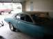 1993 Ford Bronco - Teal coupe and red Ford Bronco in a garage, with another car outside.