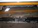 1978 Ford Bronco - The underside of a vehicle shows a chrome rear bumper and frame components, with yellow support bars overhead.