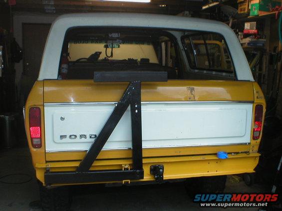 Yellow and white 1978 Ford Bronco rear view with a black swing-away spare tire carrier