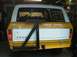 1978 Ford Bronco - Rear view of a yellow and white 1978 Ford Bronco, equipped with a swing-away spare tire carrier.