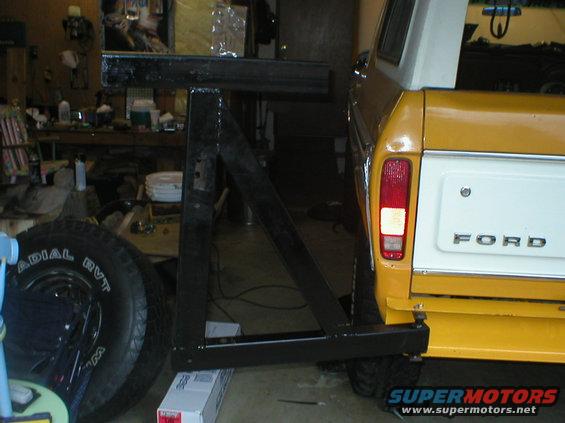 Yellow and white Ford Bronco rear bumper with spare tire mount. Ford badging visible