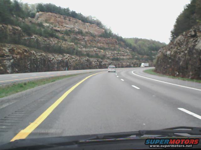 Highway driving scene with a white van and a truck visible in the distance