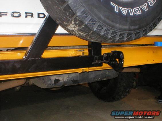 White Ford Bronco rear bumper with yellow frame, black spare tire mount, and tow hitch