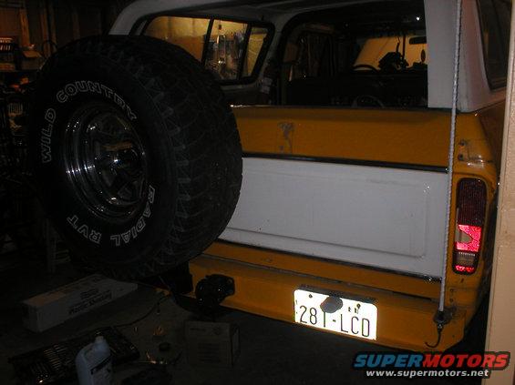 Rear bumper and spare tire of a yellow and white SUV