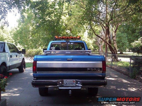 Rear view of blue 1992 Ford F-150 with toolbox and light bar