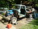 1979 Ford Bronco - Pickup truck undergoing restoration with engine removed and parts scattered around.