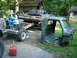 1979 Ford Bronco - A green truck cab sits on grass next to a chassis with a blue engine, suggesting a project vehicle.