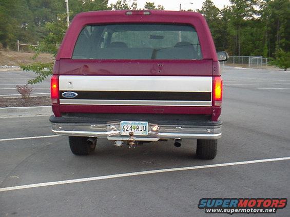 Maroon Ford Bronco rear view with a silver and black stripe across the tailgate