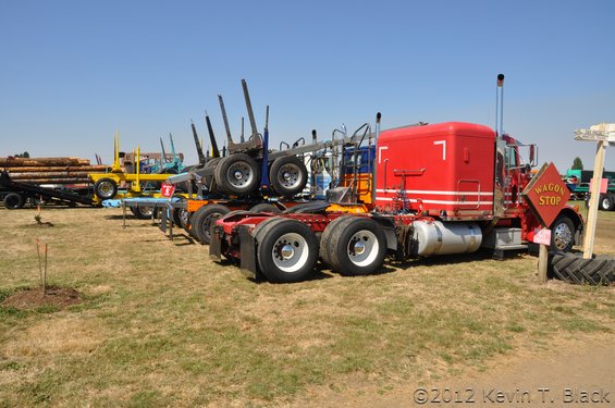 Red semi-truck with logging trailer, 3q-front view