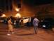 1993 Ford Probe - A group of people stand around several cars in a dimly lit parking lot at night, with a building in the background.