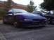 1993 Ford Probe - A blue sports coupe is parked in a lot, with another similar vehicle visible behind it.