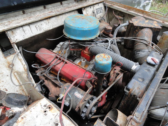 Engine bay with a red engine block, blue air filter, and various hoses and wires