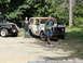 1962 International Scout 80 - Two men stand near a weathered International Scout and a black Jeep on a sunny day.