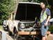 1962 International Scout 80 - A man stands beside a weathered International Scout 80, its hood raised to reveal the engine compartment.