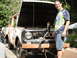 1962 International Scout 80 - A man stands next to a weathered International Scout with its hood raised, revealing the engine bay.