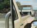 1962 International Scout 80 - A weathered International Scout is seen on the road, partially obscured by a tan truck.