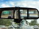 1962 International Scout 80 - A view from inside a vehicle, with decorative items hanging from the rearview mirror, reflecting a truck on the road ahead.