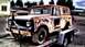 1962 International Scout 80 - A weathered International Scout is loaded onto a trailer, showing significant rust and damage.