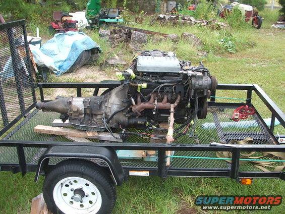 Engine and transmission assembly on a trailer, with "SUPER MOTORS" visible