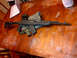 1989 Ford Bronco - An SKS rifle and a handgun are laid out on a wooden table, with a laptop in the background.