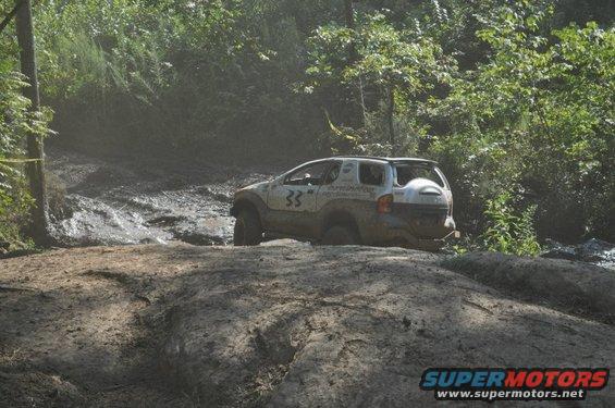 Off-road SUV with number 33 on door stuck in mud on a trail